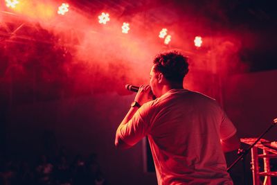 Rear view of man singing in music concert