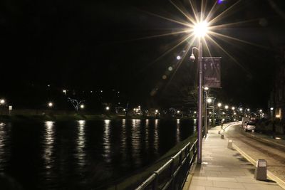 Road passing through illuminated city at night