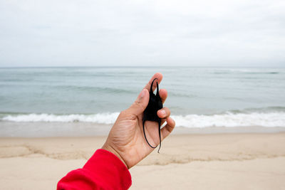 A tourist holds up a beach treasure