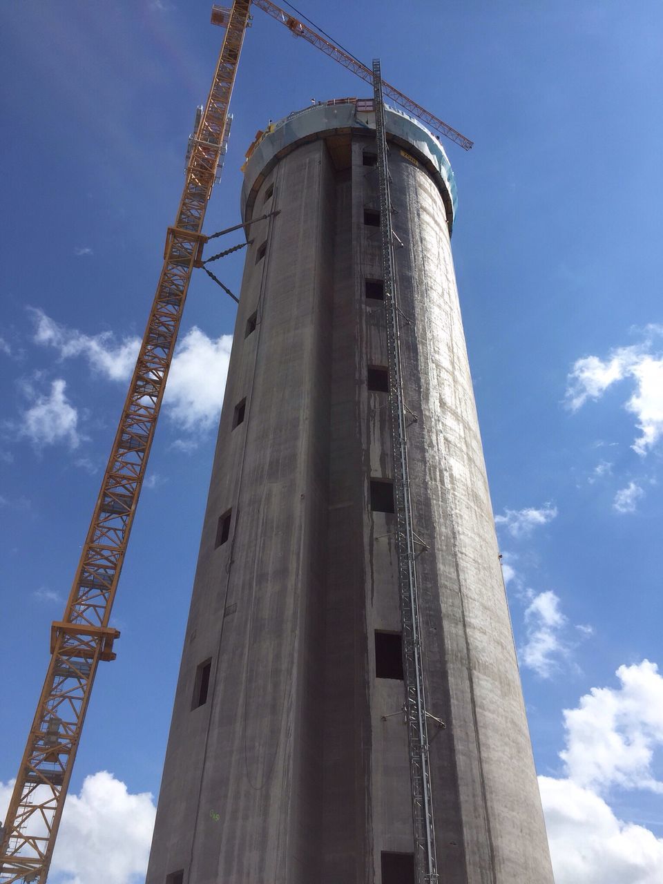 low angle view, built structure, architecture, industry, sky, building exterior, construction site, tall - high, development, crane - construction machinery, tower, factory, construction, blue, fuel and power generation, crane, metal, technology, outdoors, tall