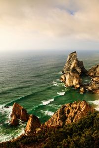 Rock formations by sea against sky