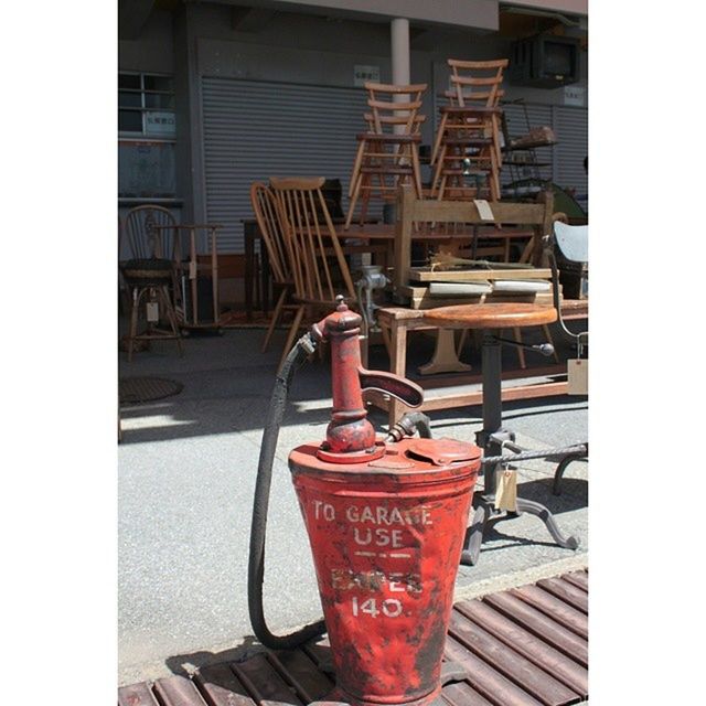 transfer print, auto post production filter, architecture, building exterior, red, built structure, metal, close-up, still life, focus on foreground, no people, table, day, indoors, container, drink, food and drink, factory, industry