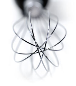 Close-up of wire whisk on white background