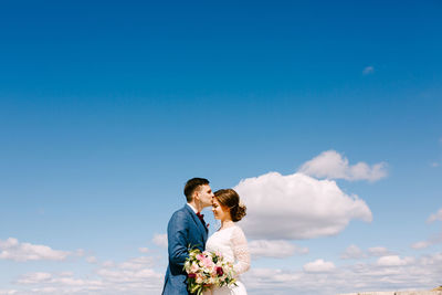 Man and woman standing against sky