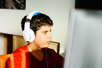 Close-up of boy playing video game at home