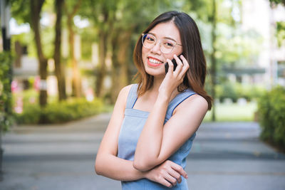 Smiling young woman using mobile phone