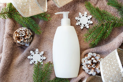 Winter cosmetic bottle shampoo, lotion or gel with christmas decorations, body care products 