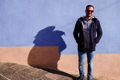 Portrait of man standing against wall