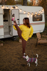 A red-haired caucasian woman stands in a twine against the background of a motor home. traveling on