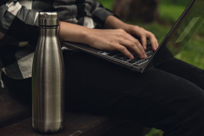 Water bottle. reusable steel thermo water bottle on wooden bench. sustainable lifestyle. plastic