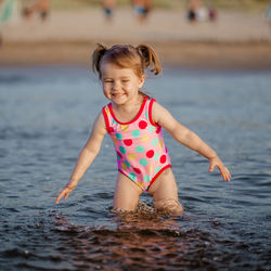 Cute girl playing in sea at beach