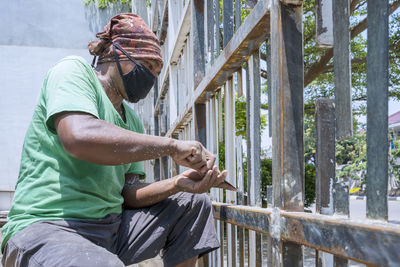 Side view of man sitting outdoors