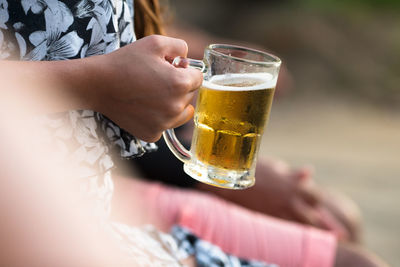 Midsection of woman drinking glass