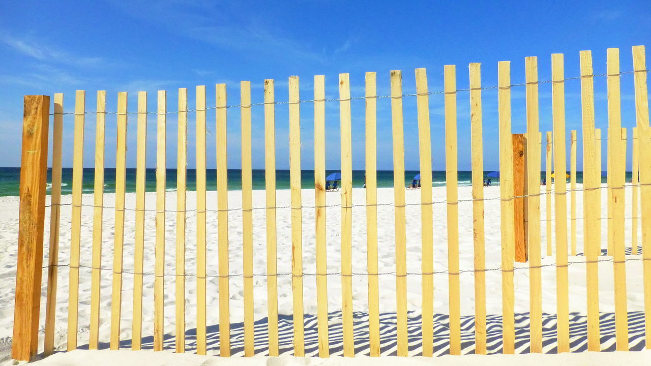 LOW ANGLE VIEW OF METAL FENCE AGAINST SKY