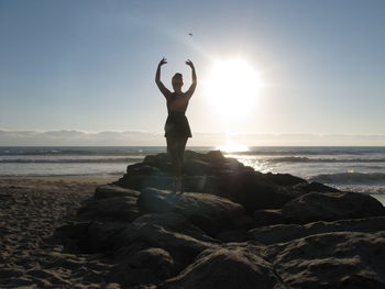 Rear view of woman ballet dancing at the beach