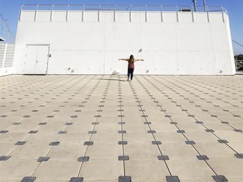 Full length rear view of man standing against building