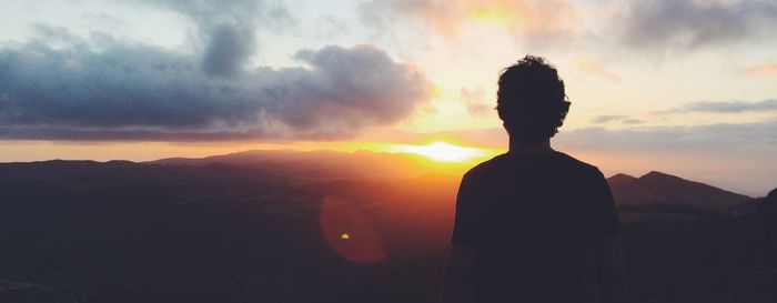 Silhouette man standing against sky during sunset