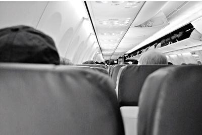 Rear view of man sitting in airplane