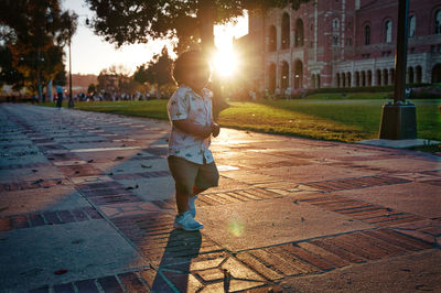 Full length of man on street in city during sunset