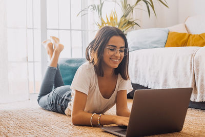 Young woman using laptop while sitting at home