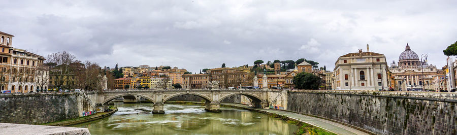 Bridge over river against buildings in city