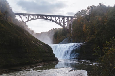 Scenic view of waterfall against bridge