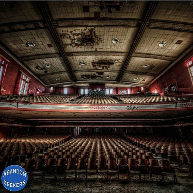 indoors, ceiling, illuminated, architecture, interior, lighting equipment, built structure, in a row, low angle view, hanging, text, no people, architectural column, pattern, repetition, arts culture and entertainment, incidental people, architectural feature, design, railroad station