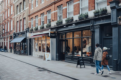 People walking on sidewalk by street in city