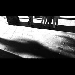 Low section of people standing on tiled floor