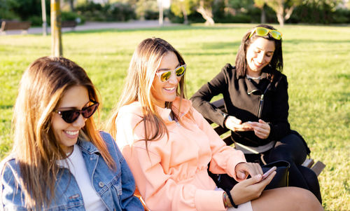 Young woman wearing sunglasses sitting outdoors