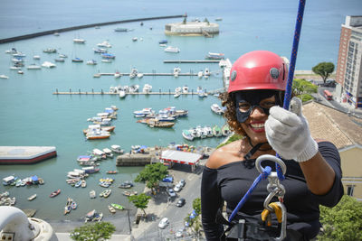 A woman wearing a hero costume with protective helmet walking down a tall rappel building. 