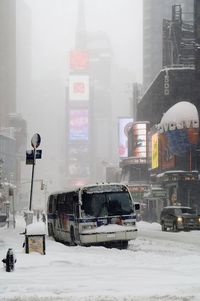 Snow covered road in city