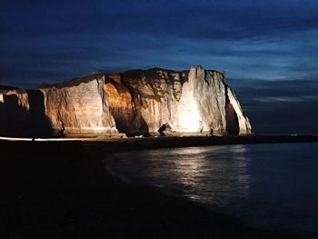 Scenic view of sea by cliff against sky