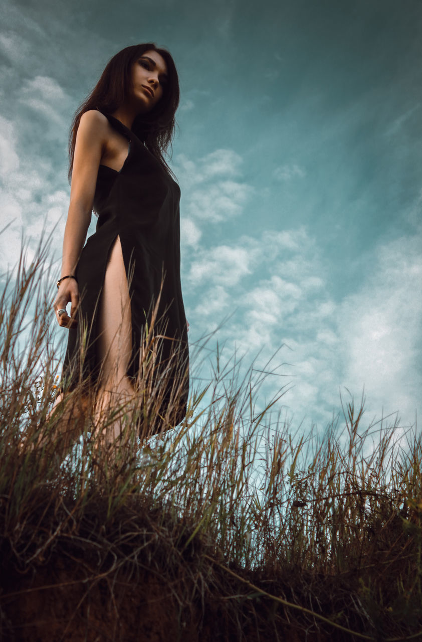 young adult, young women, low angle view, beauty, sky, person, bare tree, casual clothing, looking at camera, long hair, nature, blue, beautiful people, tranquility, beauty in nature, outdoors, posing, scenics, day, tranquil scene, attitude