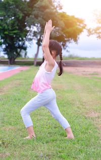 Full length of woman with arms raised on field