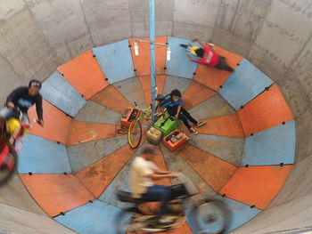 High angle view of woman standing on multi colored umbrella
