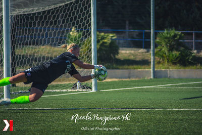 Woman playing soccer ball on field