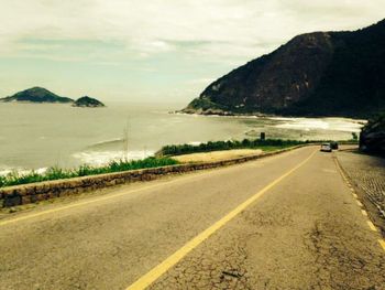 Road by landscape against sky