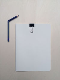 Directly above view of papers with binder clip by broken pencil on table