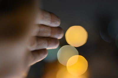 Close-up of hand against lens flare