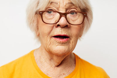 Close-up of senior woman against white background