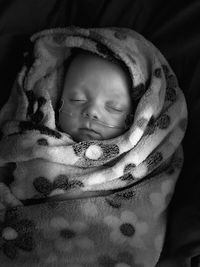 Close-up of cute baby boy in intensive care against black background