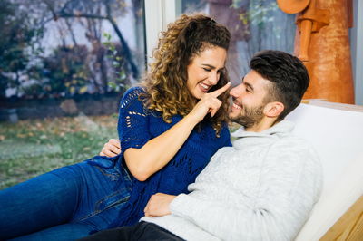 Smiling young couple sitting at home