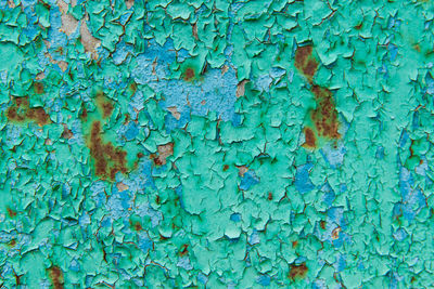 Closeup of old peeling green paint on a metal surface. abstract industrial vintage pattern texture