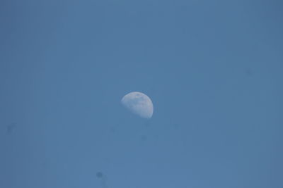 Low angle view of moon against blue sky at night