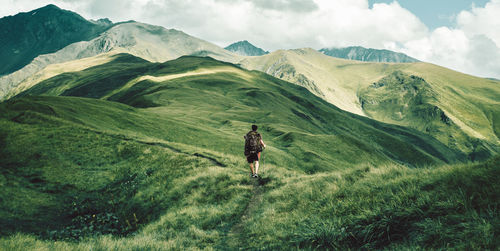 Rear view of man walking on mountain road