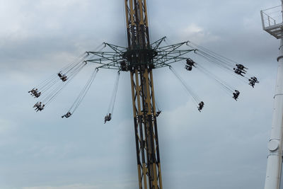 Low angle view of chain swing ride against sky