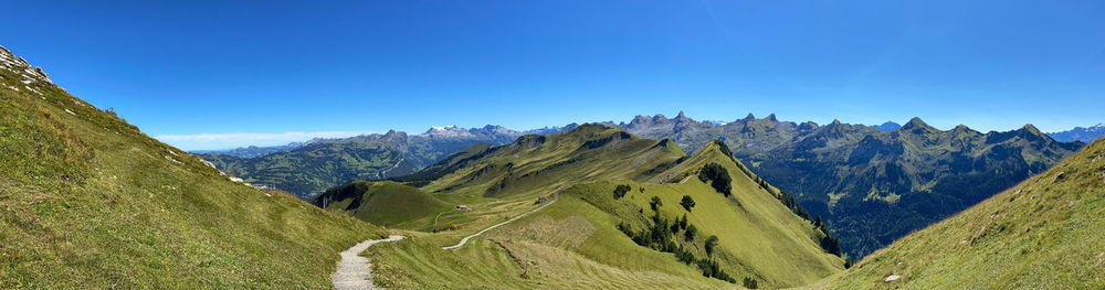 Panoramic view of landscape and mountains against clear blue sky