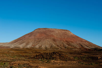 Scenic view of mountains against clear blue sky