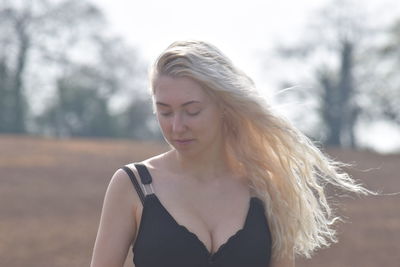 Portrait of beautiful woman standing against blurred background